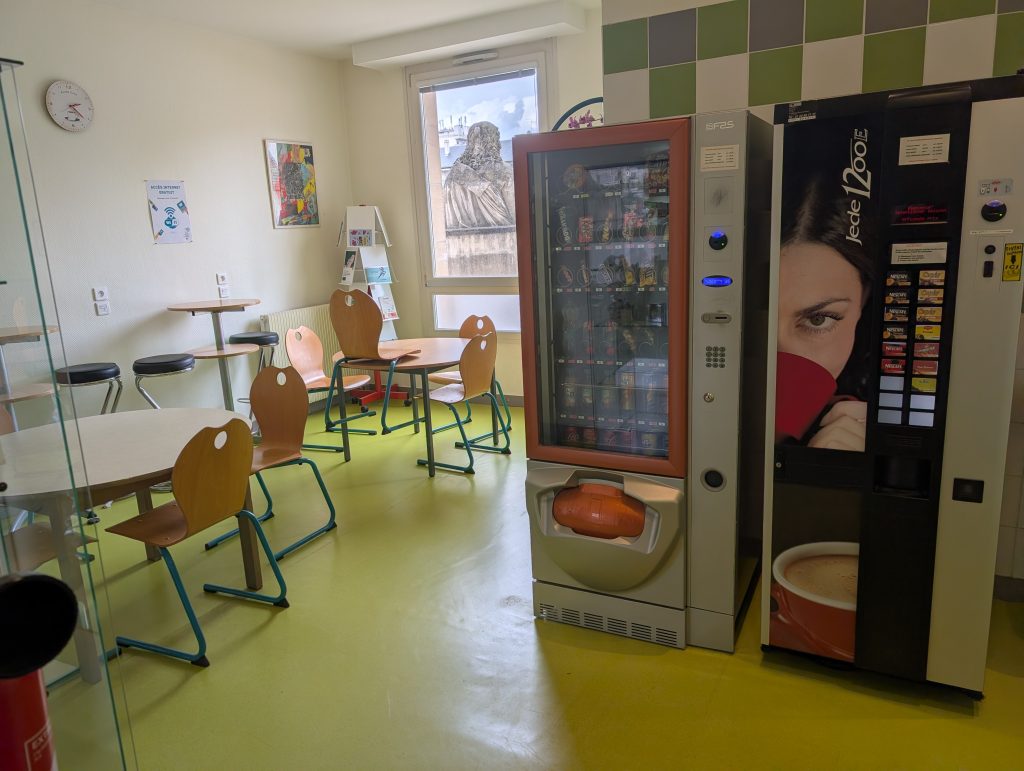 L'espace détente de l'association dispose de deux distributeurs de boissons et d'en-cas. Plusieurs tables y sont installées pour vous permettre de déjeuner.